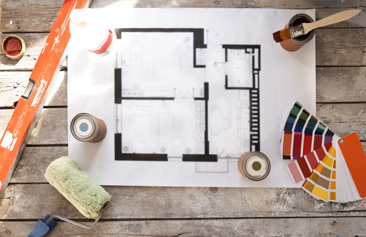 Plans de rénovation et documents d'assurance construction sur une table
